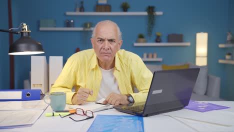 Home-office-worker-old-man-looking-nervously-at-camera.